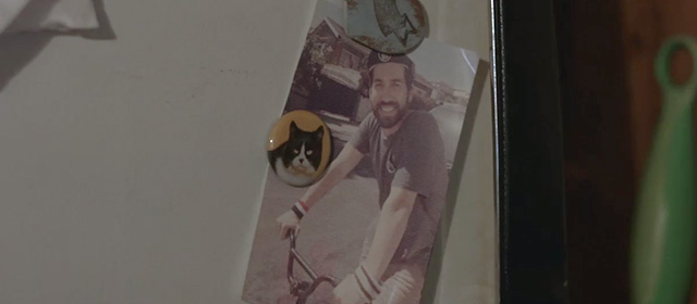 The 4th - photo of roommate Derek on bike held up by tuxedo cat magnet