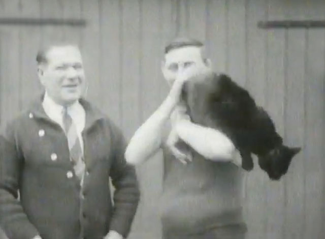 Alex Ireland in Training - holding large black cat