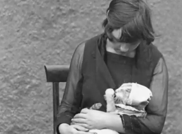 All In the Day - tabby cat wearing baby bonnet being fed from bottle by teenage girl