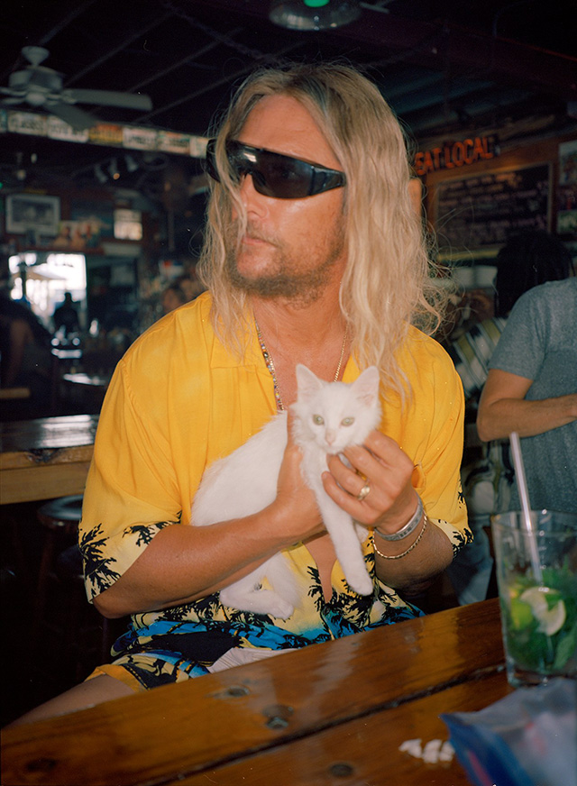 The Beach Bum - Moondog Matthew McConaughey at outdoor bar with tiny white kitten