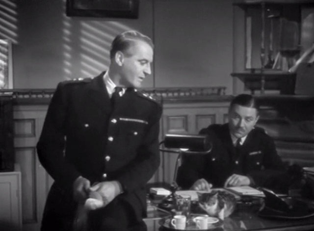 Cairo Road - Colonel Bey Eric Portman at desk with tiny tabby kitten drinking milk