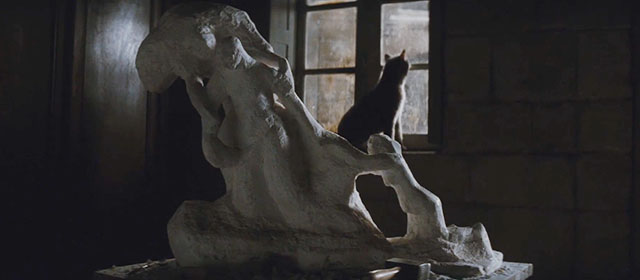 Camille Claudel - gray cat sitting on windowsill looking out window at rain