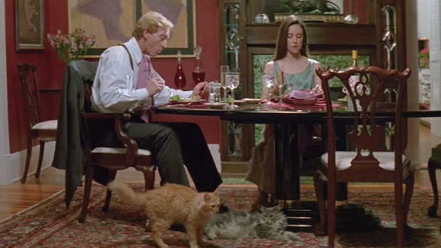 China Moon - Rupert Charles Dance and Rachel Madeleine Stowe sitting at dinner table with long-haired tabby cats on floor