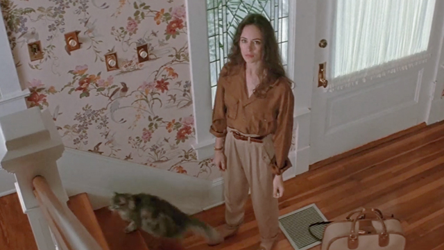China Moon - Rachel Madeleine Stowe standing at bottom of stairs with long-haired tabby cat going up