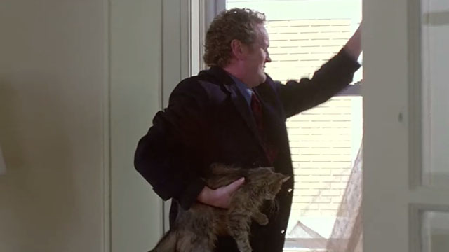 Claire Dolan - Cain Colm Meaney holding longhair tabby cat at window