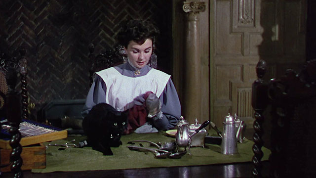 Footsteps in the Fog - Lily Jean Simmons polishing silver with black cat Missy looking nervous on desk