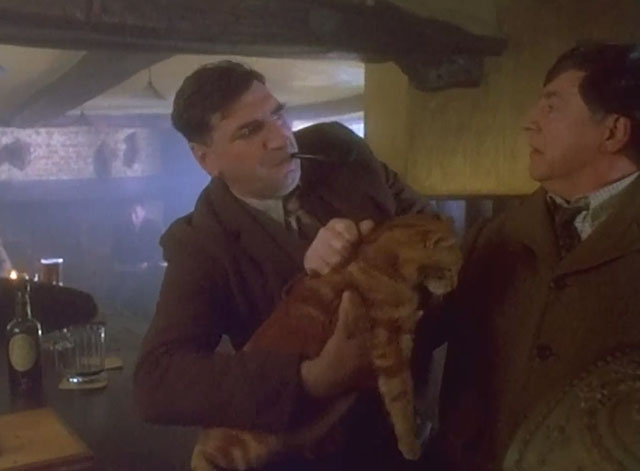 Grotesque - Sir Hugo Coal Alan Bates holding ginger tabby cat on bar as George Jim Carter intervenes