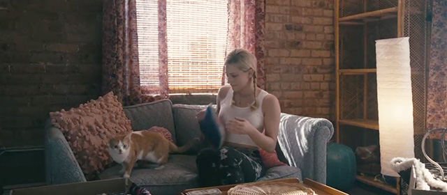 Hustlers - Annabelle Lili Reinhart on couch with orange and white tabby cat