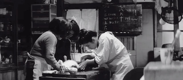 The Insect Woman - Hanako holding tabby and white cat down on table as Take draws blood