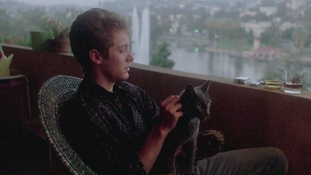 Jack's Back - Rick James Spader sitting on balcony with grey cat on lap