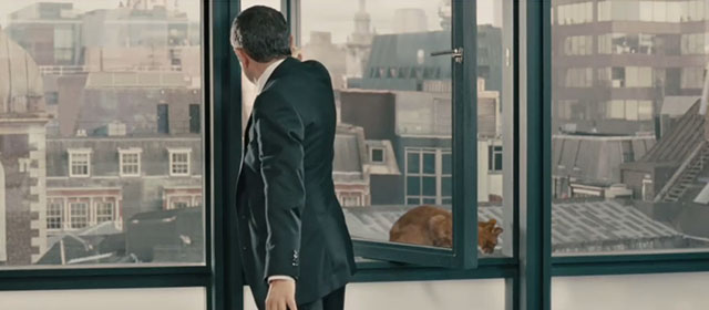 Johnny English - Rowan Atkinson closing window with ginger tabby cat Philby on sill