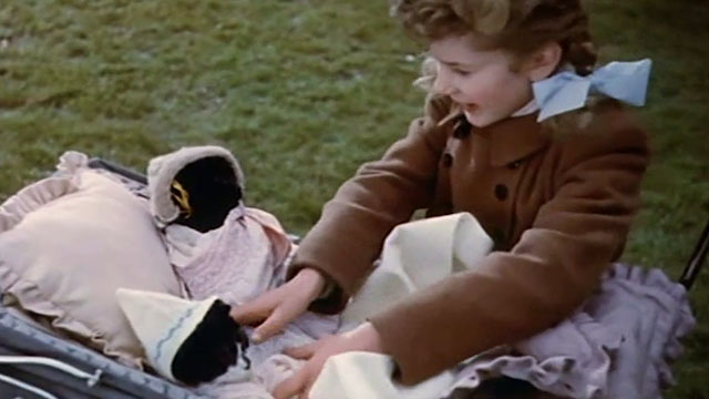 Josephine and Men - young Josephine playing dress up with a black cat and a tuxedo cat in a baby buggy