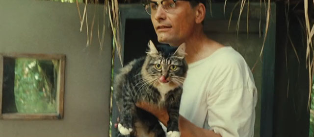 On the Road - Old Bull Lee Viggo Mortensen holding up longhair tabby and white cat