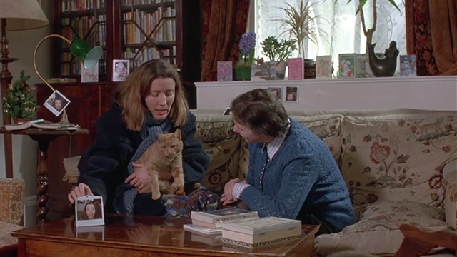 Peter's Friends - Maggie Emma Thompson holding ginger tabby cat Michael on couch with elderly woman