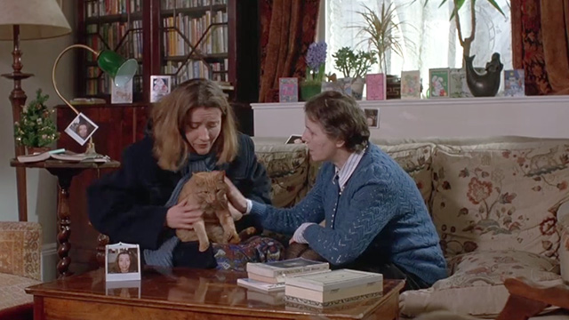 Peter's Friends - Maggie Emma Thompson holding ginger tabby cat Michael on couch with elderly woman