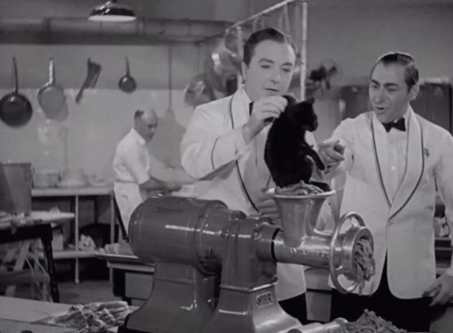 Pick a Star - black kitten picked up by scruff by Joe Jack Haley about to be put into meat grinder with Tony Benny Burt