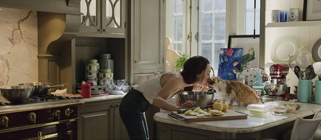 The Protégé - Anna Maggie Q kissing ginger and white tabby cat on kitchen counter