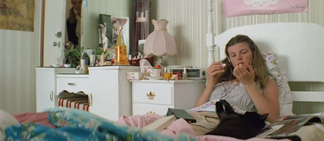 Puberty Blues - Debbie Nell Schofield sitting up on bed with black cat