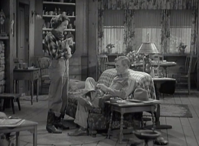 Racing Lady - Ruth Ann Dvorak holding tabby cat in front of Tom Harry Carey with second tabby cat on couch