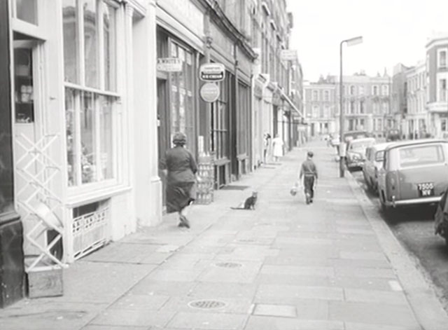 Seventy Deadly Pills - cat on sidewalk outside shops