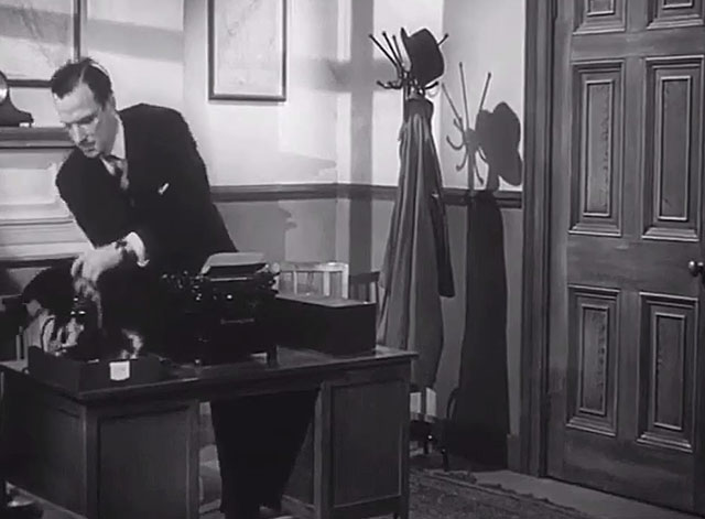 The Six Men - Hunter Michael Evans lifting tuxedo cat from tray on desk