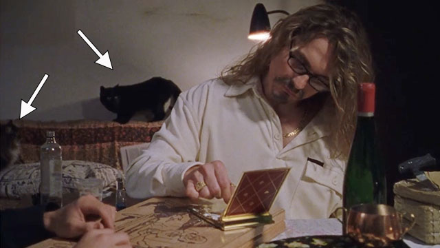 The Shield - Blowback - black cat and longhair brown and white tabby cat on couch behind Kurt Sutter