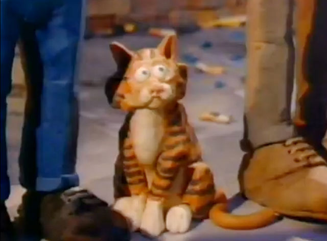 Vanz Kant Danz - John Fogerty - claymation cat sitting by feet on sidewalk